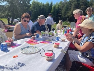 Personer som firar DHR:s 100-årdag med färgglada bakelser till fikat.