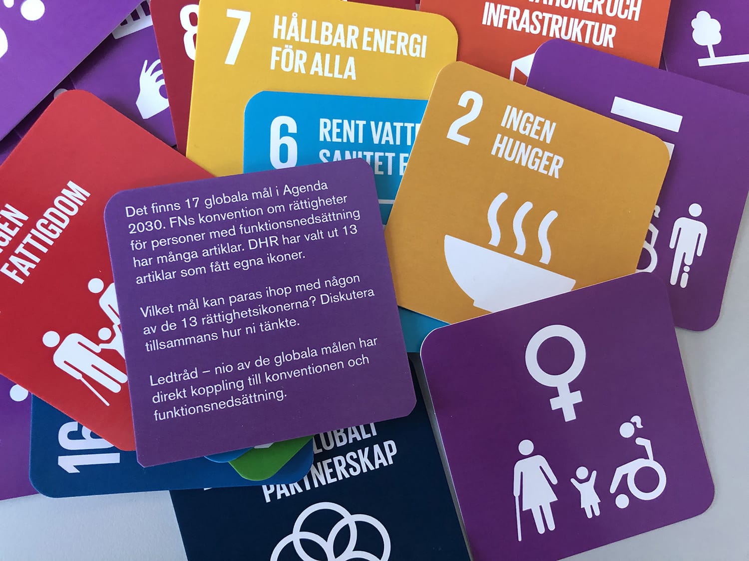 Kortlek utlagd med bilder av Rättighetsikoner (syrenlila) och Agenda 2030:s mål (olika färger).