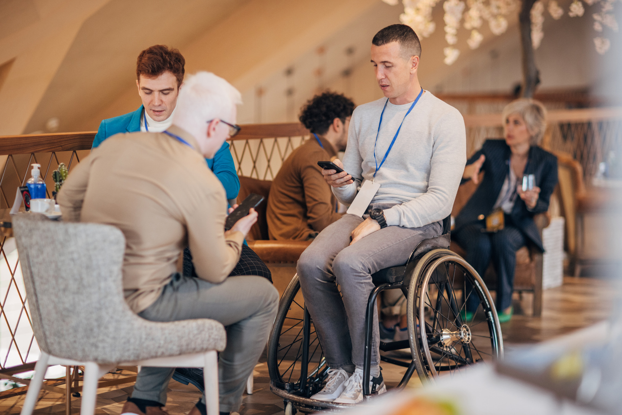 En grupp personer sittande i en soffgrupp samtalar med varandra.